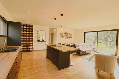 a kitchen and living room with a table and a couch at Maison en Corse in Monacia-dʼAullène