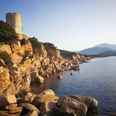 a lighthouse on the side of a rocky shore at Maison en Corse in Monacia-dʼAullène
