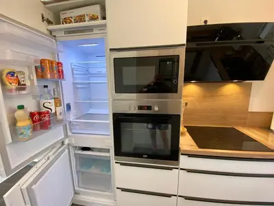 a kitchen with an open refrigerator with two microwaves at villa CASA TOTTI vue mer avec piscine in Porto-Vecchio