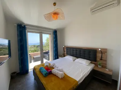 a bedroom with a bed and a large window at villa CASA TOTTI vue mer avec piscine in Porto-Vecchio