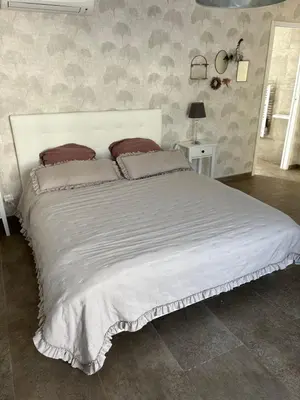 a large white bed with pillows on it in a bedroom at Villa 3 chambres avec piscine privative in Ajaccio