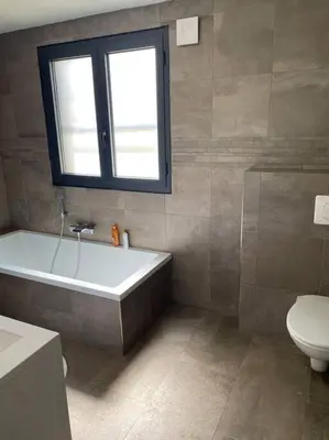 a bathroom with a tub and a toilet and a window at Villa 3 chambres avec piscine privative in Ajaccio