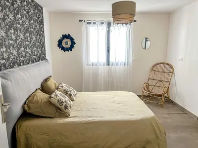 a bedroom with a bed and a window with a chair at Villa 3 chambres avec piscine privative in Ajaccio