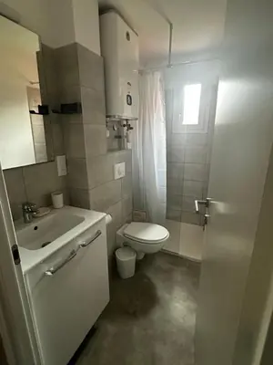 a white bathroom with a toilet and a sink at Résidence les Hameaux de Saint Cyprien appartement LUNA 132 in Lecci