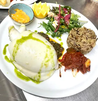 a white plate of food with meat and a salad at Résidence les Hameaux de Saint Cyprien appartement LUNA 132 in Lecci