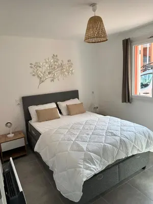 a bedroom with a large bed with white sheets at Résidence les Hameaux de Saint Cyprien appartement LUNA 132 in Lecci