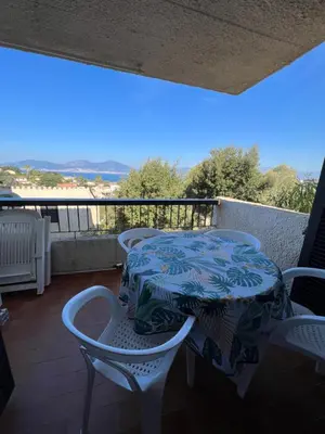 a table and chairs on a balcony with a view at Bella Vista 34 , T2 vue mer, piscine ,climatisé Porticcio in Porticcio