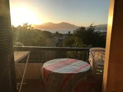 a balcony with a table and a view of the ocean at Bella Vista 34 , T2 vue mer, piscine ,climatisé Porticcio in Porticcio