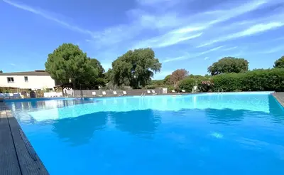 a large swimming pool with blue water at Appart Cala Rossa - Porto-Vecchio - Mer à pied in Lecci
