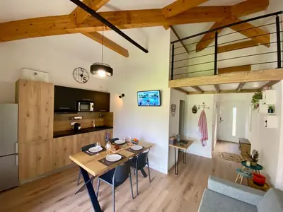a dining room and living room with a table and chairs at Appart Cala Rossa - Porto-Vecchio - Mer à pied in Lecci
