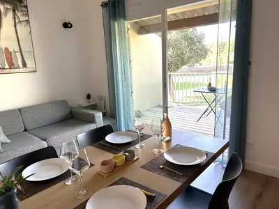a dining room table with plates and glasses on it at Appart Cala Rossa - Porto-Vecchio - Mer à pied in Lecci