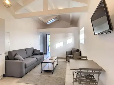 a living room with a couch and a table at Golfe de Sagone Plage du Liamone Maison pieds dans l'eau in Casaglione