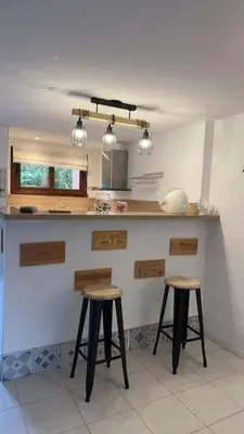 a kitchen with two bar stools and a counter at Résidence Marina di pinarello Mini Villa 6 personnes à 400 m de la plage in Zonza