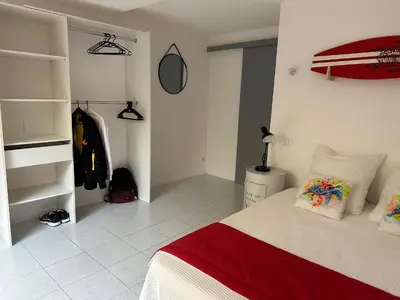 a bedroom with a bed with a red and white blanket at Résidence Marina di pinarello Mini Villa 6 personnes à 400 m de la plage in Zonza
