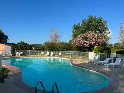 a swimming pool with chairs and a fence at Résidence Marina di pinarello Mini Villa 6 personnes à 400 m de la plage in Zonza