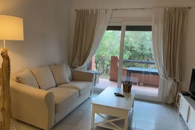 a living room with a white couch and a table at Résidence Marina di pinarello Mini Villa 6 personnes à 400 m de la plage in Zonza