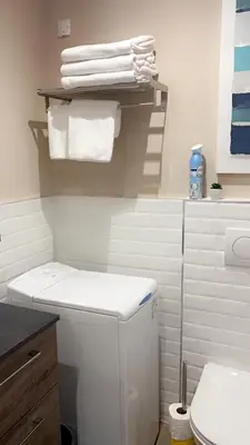 a white bathroom with a toilet and towels at Bel appartement dans Villa avec piscine en Corse du Sud in Grossa