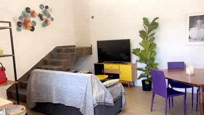 a living room with a table and a television at Bel appartement dans Villa avec piscine en Corse du Sud in Grossa