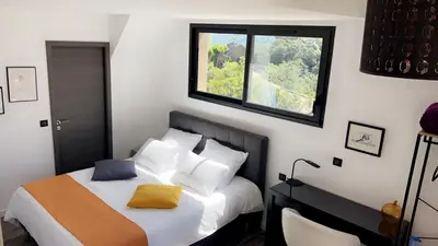 a bedroom with a bed and a window at Bel appartement dans Villa avec piscine en Corse du Sud in Grossa