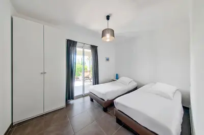 a bedroom with two beds and a window at Résidence Pierre & Vacances Premium Les Villas de Porto-Vecchio in Porto-Vecchio