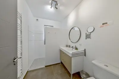 a white bathroom with a sink and a mirror at Résidence Pierre & Vacances Premium Les Villas de Porto-Vecchio in Porto-Vecchio