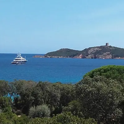 a boat in the middle of a large body of water at Villa à Pinarello-2mn à pied de la plage-vue mer in Pinarellu