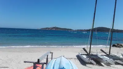 a beach with two sail boats on the beach at Villa à Pinarello-2mn à pied de la plage-vue mer in Pinarellu