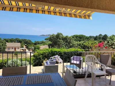 a balcony with chairs and a view of the ocean at Villa à Pinarello-2mn à pied de la plage-vue mer in Pinarellu