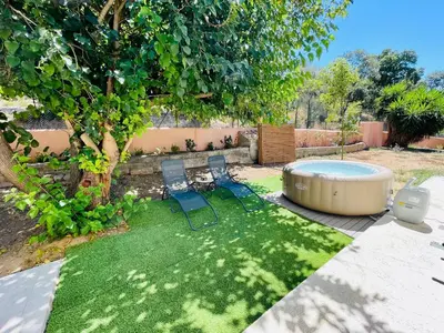 two chairs and a hot tub in a yard at Maison d’hôtes Joséphine in Ajaccio