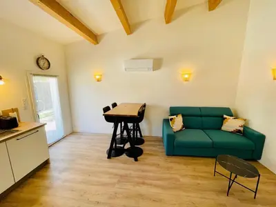 a living room with a green couch and a table at Maison d’hôtes Joséphine in Ajaccio