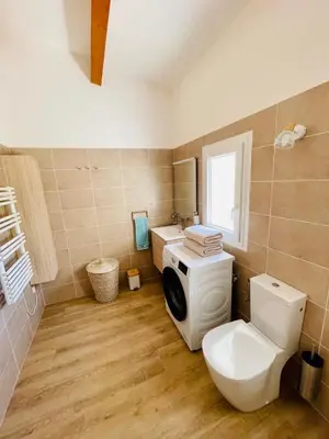 a bathroom with a washing machine and a toilet at Maison d’hôtes Joséphine in Ajaccio