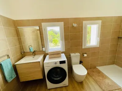 a bathroom with a washing machine and a toilet at Maison d’hôtes Joséphine in Ajaccio