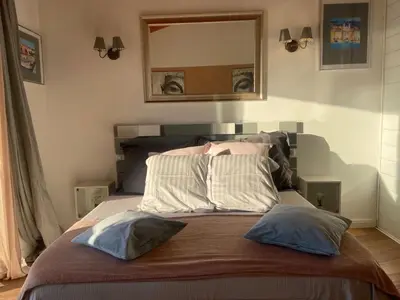 a bedroom with a bed with two pillows and a mirror at Villa Santoni 2 in Grosseto-Prugna
