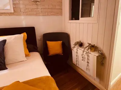 a bedroom with a bed and a chair and a window at Villa Santoni 2 in Grosseto-Prugna