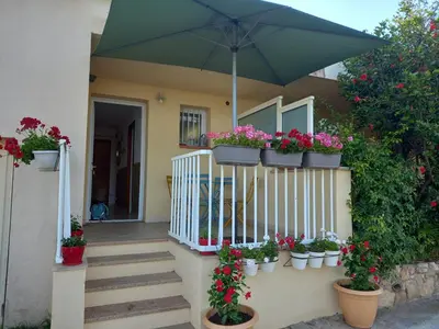 a house with potted plants and an umbrella at A CASA DI ROSA in Serra-di-Ferro