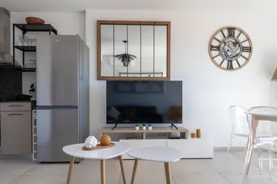 a kitchen with a table and a refrigerator at La Lond'ella - Appt à 1,5km de la mer à Porticcio in Grosseto-Prugna