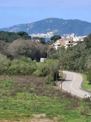 a winding road on a hill with houses in the distance at La Lond'ella - Appt à 1,5km de la mer à Porticcio in Grosseto-Prugna