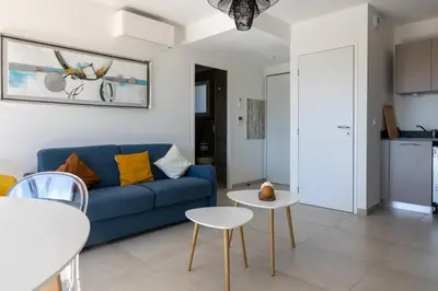 a living room with a blue couch and two tables at La Lond'ella - Appt à 1,5km de la mer à Porticcio in Grosseto-Prugna