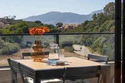 a table with a vase of flowers and a glass at La Lond'ella - Appt à 1,5km de la mer à Porticcio in Grosseto-Prugna