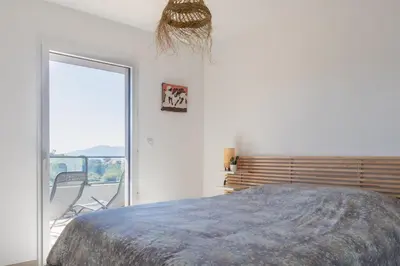 a bedroom with a bed and a sliding glass door at La Lond'ella - Appt à 1,5km de la mer à Porticcio in Grosseto-Prugna
