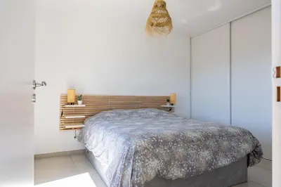 a bedroom with a bed with a wooden headboard at La Lond'ella - Appt à 1,5km de la mer à Porticcio in Grosseto-Prugna