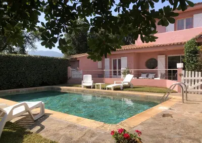 a swimming pool with two chairs and a house at Villa de charme à Marina di fiori in Porto-Vecchio