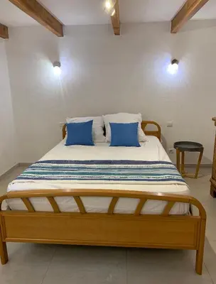 a large bed with blue pillows in a room at Villa de charme à Marina di fiori in Porto-Vecchio