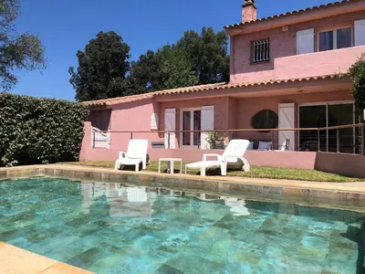 a house with two chairs and a swimming pool at Villa de charme à Marina di fiori in Porto-Vecchio