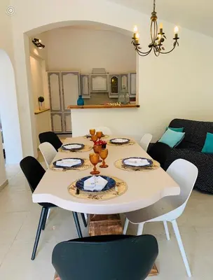 a white dining room table with chairs and a couch at Villa de charme à Marina di fiori in Porto-Vecchio