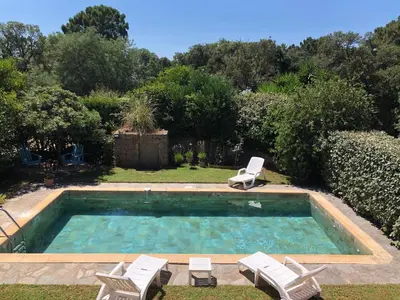 a swimming pool with two lawn chairs and two loungers at Villa de charme à Marina di fiori in Porto-Vecchio