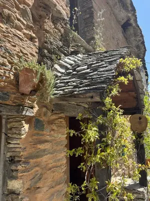 an old stone building with a window with plants at Le Refuge de la Tour entre mer et ciel in Porri