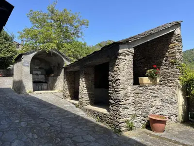 an old stone building with a door and a window at Le Refuge de la Tour entre mer et ciel in Porri