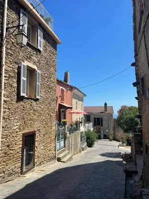 a stone building with a street in front of it at Le Refuge de la Tour entre mer et ciel in Porri