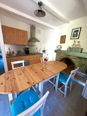 a kitchen with a wooden table and chairs at A Torra entre mer et ciel in Porri